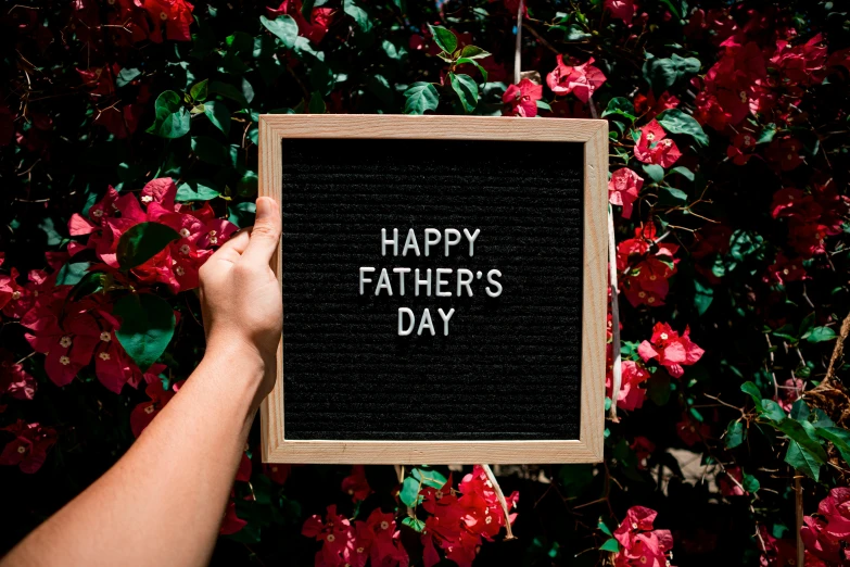 a person holding a sign that says happy father's day, pixabay, instagram post, billboard image, black, felt