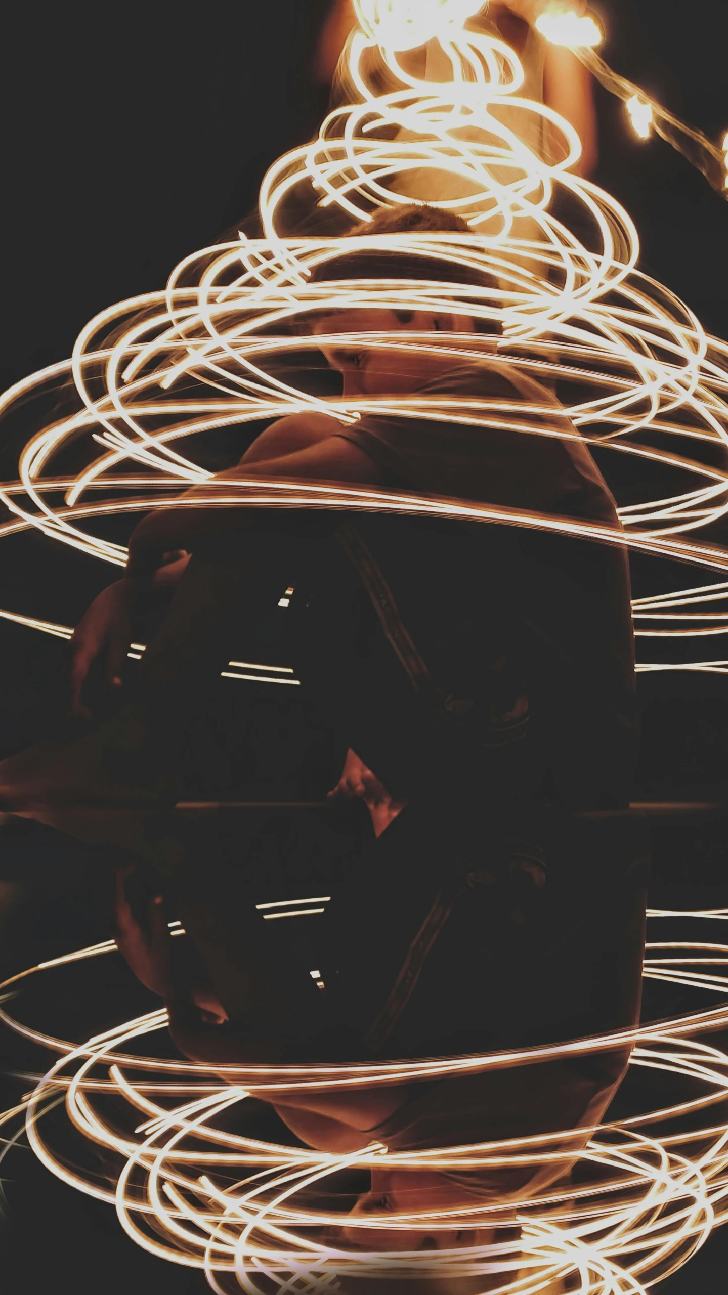 a close up of a person holding a fire ring, by Robbie Trevino, light and space, lines and movement, instagram post, wires with lights, brown