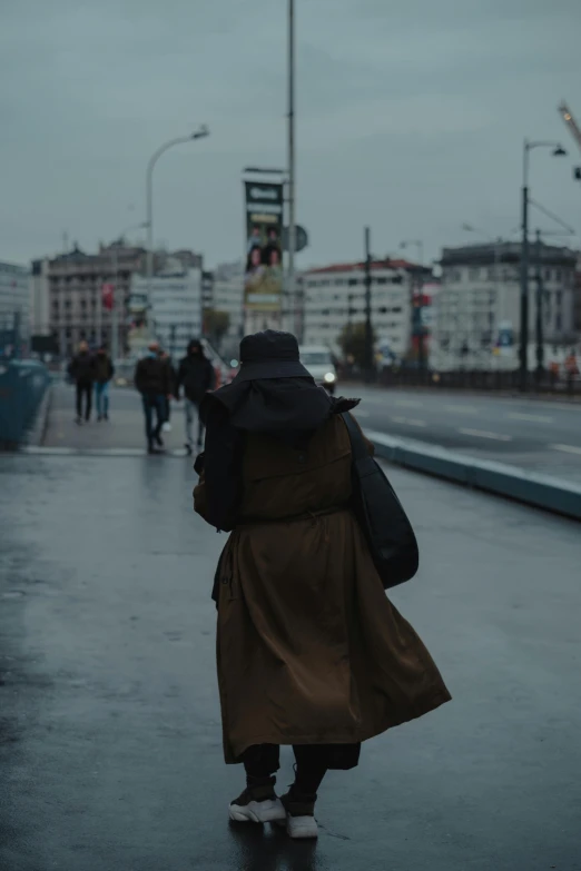 a person riding a skateboard down a wet street, by Matija Jama, woman is in a trenchcoat, walking away, movie still 8 k, portrait featured on unsplash