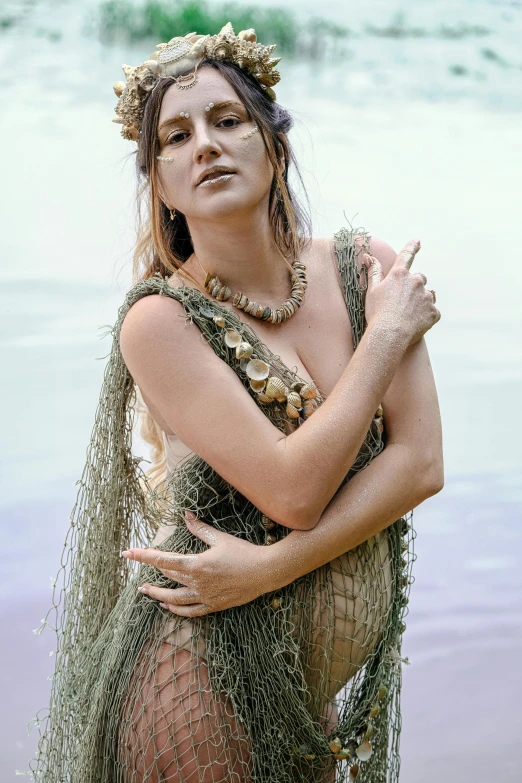 a woman that is standing in the water, an album cover, unsplash, renaissance, wearing chain mail, cottage hippie naturalist, wearing seashell attire, alluring plus sized model