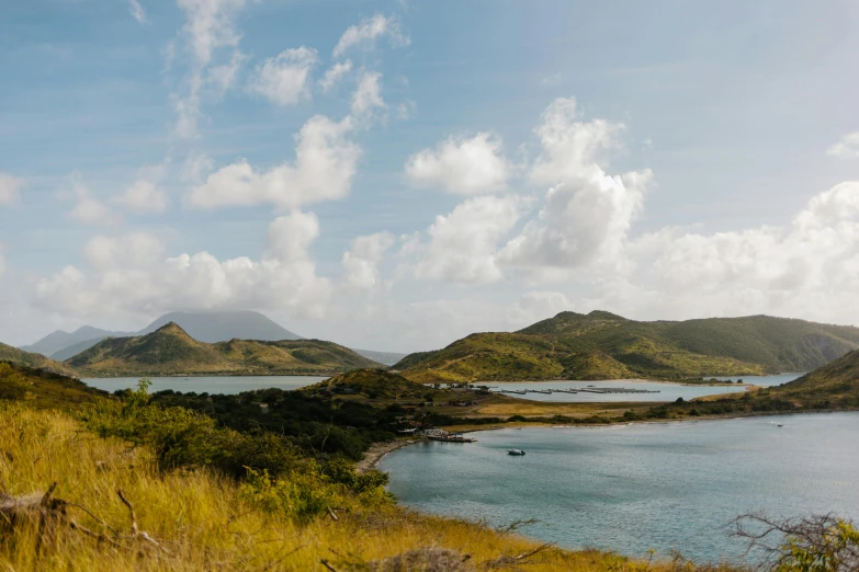 a large body of water sitting on top of a lush green hillside, by Simon Marmion, pexels contest winner, caribbean, conde nast traveler photo, brown, grey