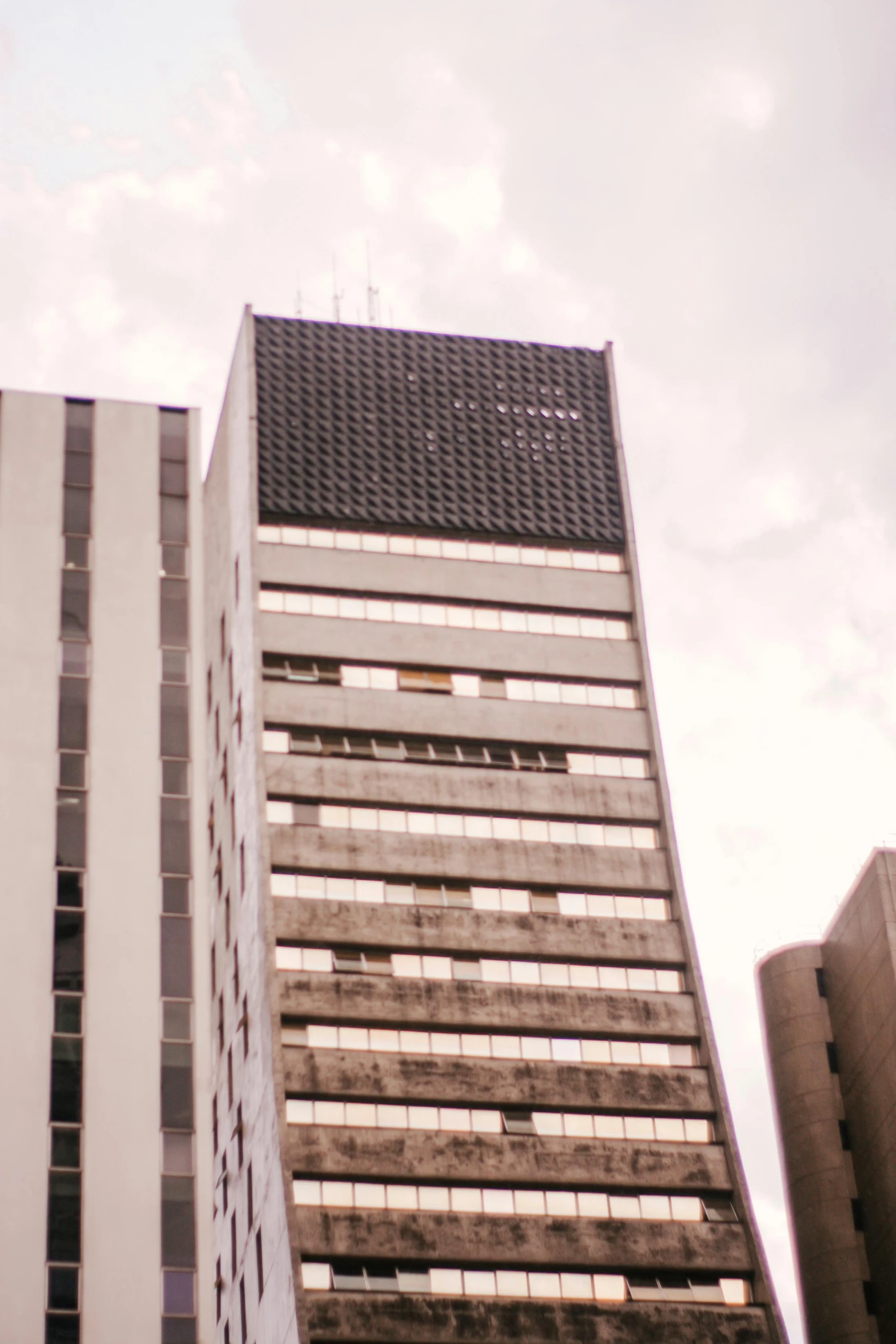 a couple of tall buildings sitting next to each other, by Pablo Rey, brutalism, 3 5 mm slide, sao paulo, low quality photo, grainy footage