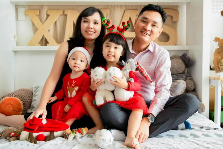 a couple of people that are sitting on a bed, a portrait, pexels contest winner, realism, wearing santa hat, an indonesian family portrait, jellycat, avatar image