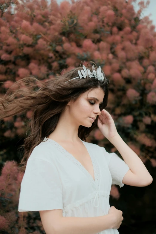 a pregnant woman wearing a tiara standing in front of a flowering tree, unsplash, baroque, featuring rhodium wires, windswept, hailee steinfeld, detail shot
