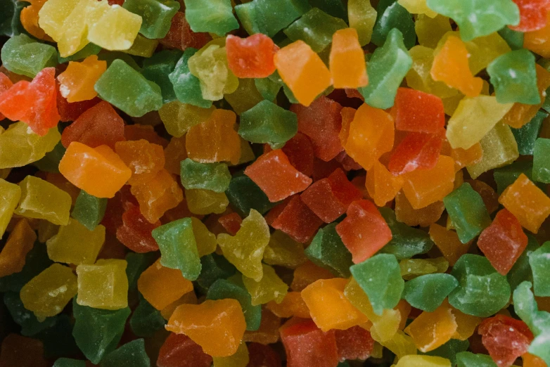 a pile of gummy bears sitting on top of a table, a mosaic, inspired by Mark Tobey, pexels, renaissance, tropical fruit, medium detail, bright green dark orange, soup