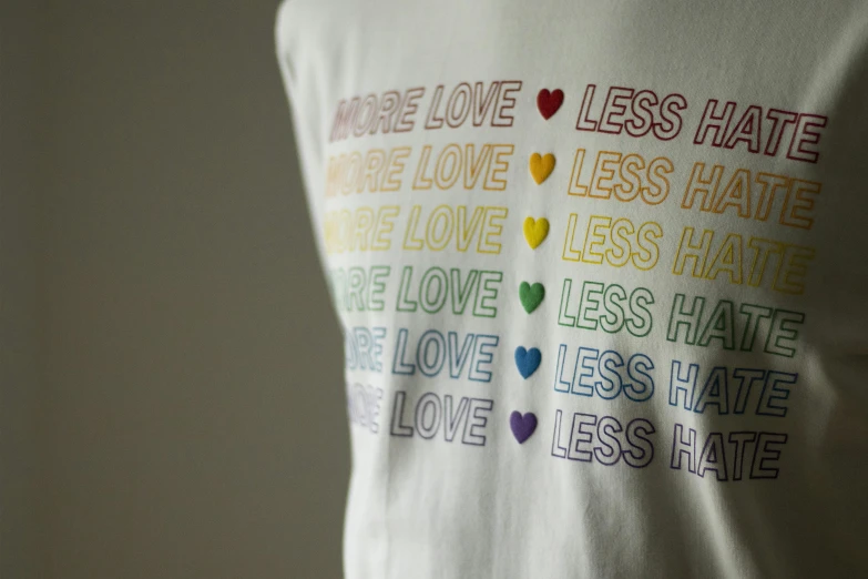 a t - shirt that says we love less hate, less hate, less hate, less hate, love less hate, less hate, less, by Nina Hamnett, unsplash, detail shot, lgbt, okuda, half length shot