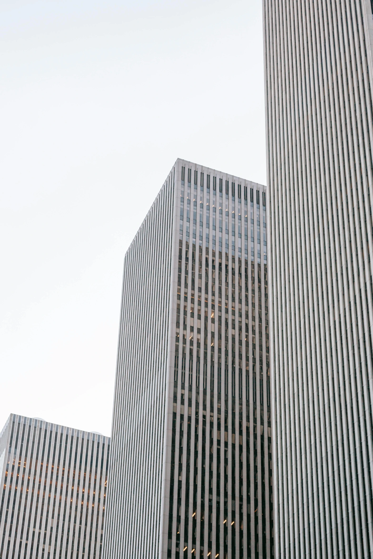 a couple of tall buildings sitting next to each other, an album cover, inspired by David Chipperfield, pexels contest winner, square lines, ny, staples, grey