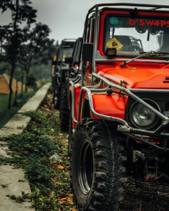 a red jeep parked on the side of a road, by Adam Marczyński, pexels contest winner, sumatraism, snake machine, in a row, traps, thumbnail