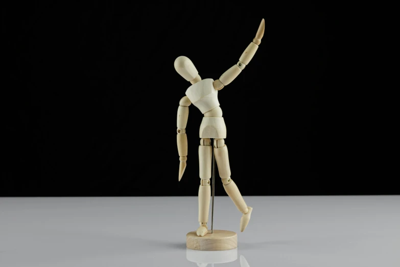 a wooden mannequin standing on a white surface, dancing a jig, celebrate goal, 1 figure only, fully posable