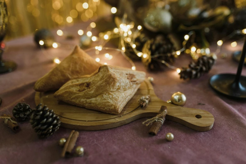 a wooden cutting board sitting on top of a table, by Alice Mason, unsplash, gold decorations, calzone zone, lights, dressed as a pastry chef