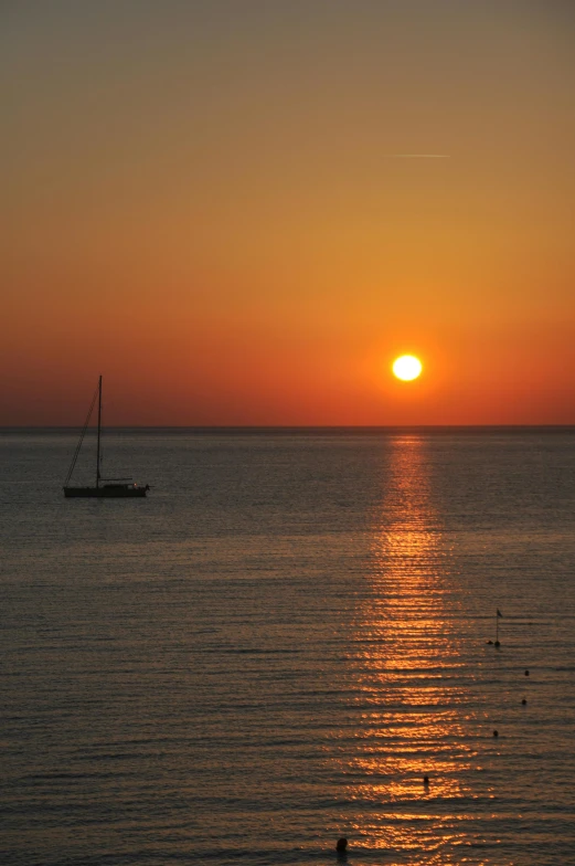 a large body of water with a boat in the distance, pexels, romanticism, orange sun set, costa blanca, july 2 0 1 1, suntur