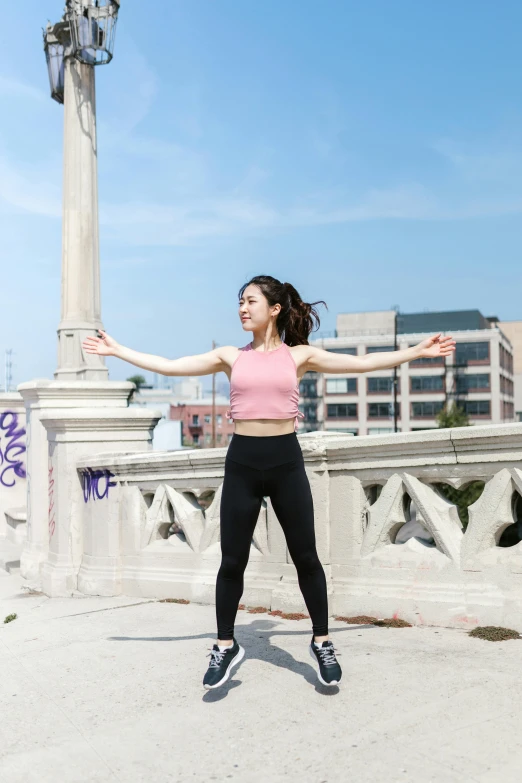 a woman standing on a bridge with her arms outstretched, inspired by helen huang, arabesque, standing on a rooftop, wearing a cropped top, fighting stance energy, profile image