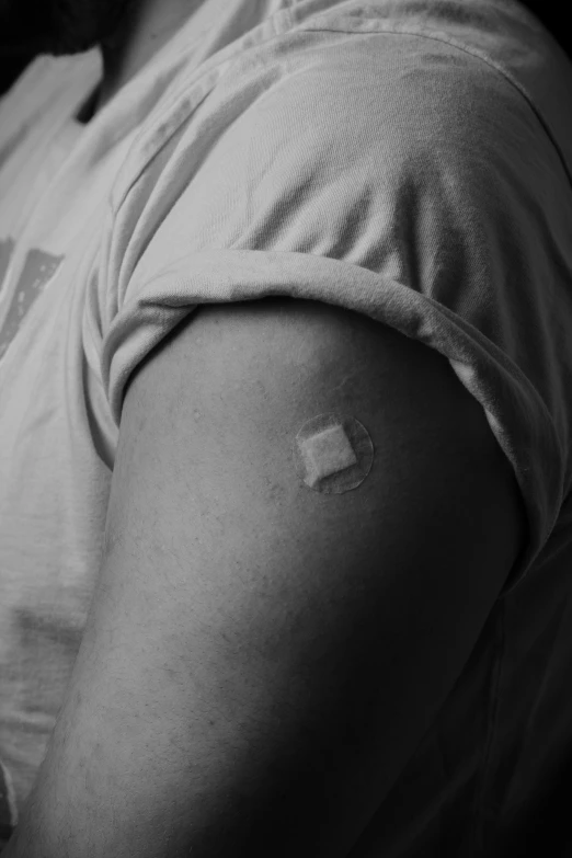 a man with a tattoo on his arm, a black and white photo, pexels, surgical iv bag, with a square, virus, stick poke