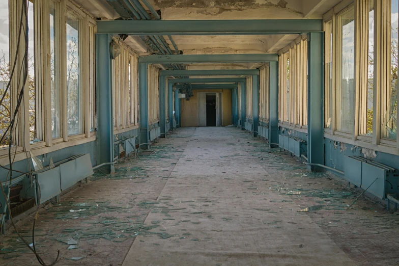 a long hallway in an abandoned building with broken windows, inspired by Elsa Bleda, unsplash, fan favorite, military base, low quality photo, blue room