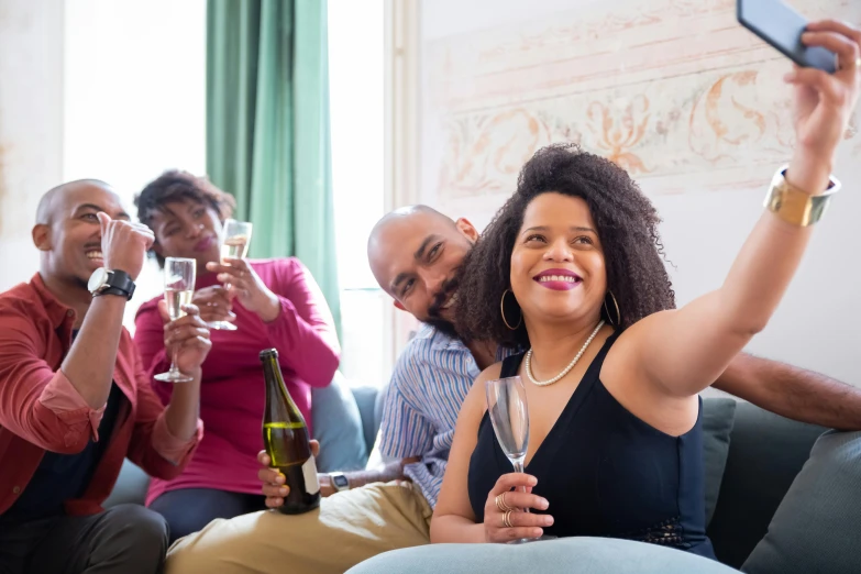 a group of people sitting on a couch holding wine glasses, pexels contest winner, happening, photo of a black woman, slide show, drinking champagne, medium head to shoulder shot