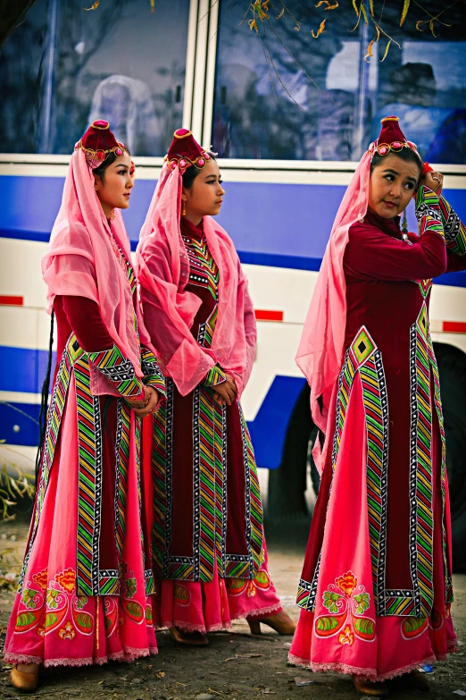 a group of women standing in front of a bus, flickr, dau-al-set, a young woman as genghis khan, award winning costume design, blue and pink shift, natgeo