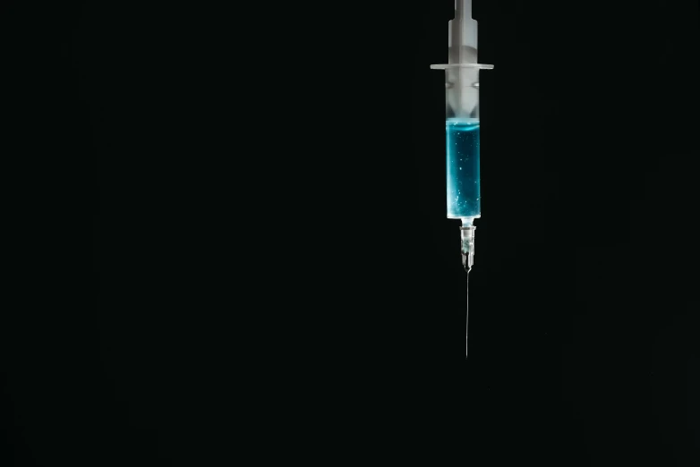 a close up of a syll on a black background, by Adam Marczyński, unsplash, conceptual art, syringe, blue colored, isolated on white background, background image