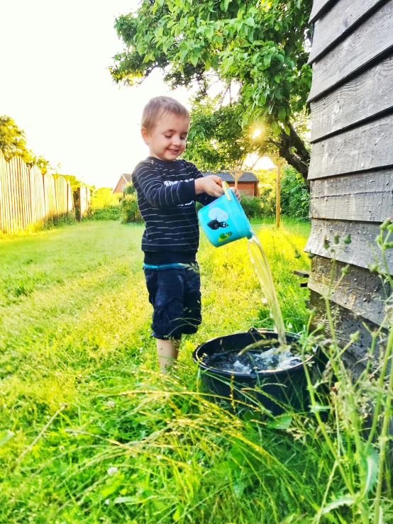 a little boy that is standing in the grass, a picture, filling with water, filled with plants, profile image, home and garden