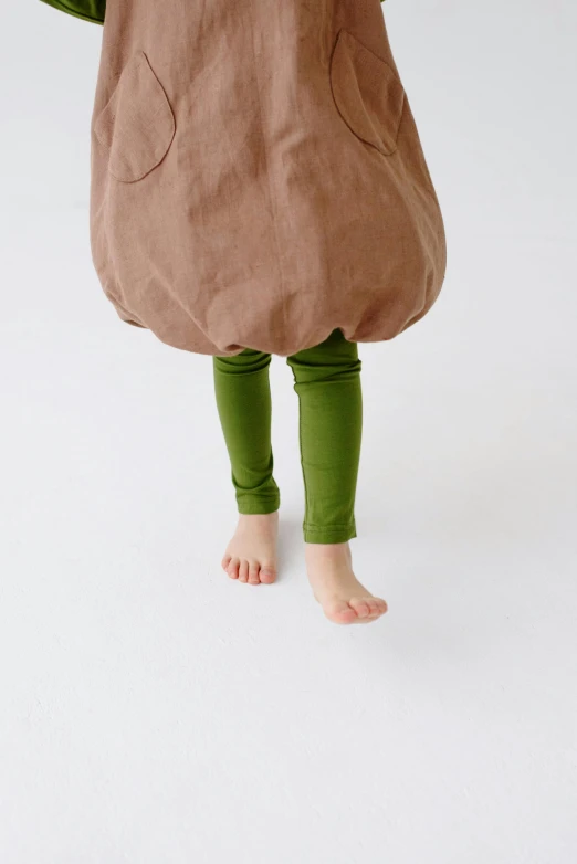 a little girl in a costume of an avocado, inspired by Elsa Beskow, unsplash, brown pants, legs, taupe, leggings