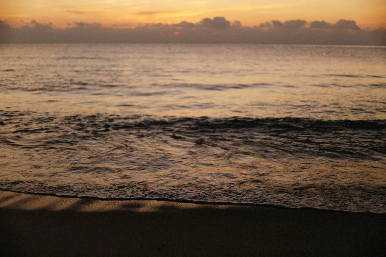 a large body of water sitting on top of a sandy beach, by Carey Morris, unsplash, sunset beach, taken in the late 2010s, hd footage, fan favorite