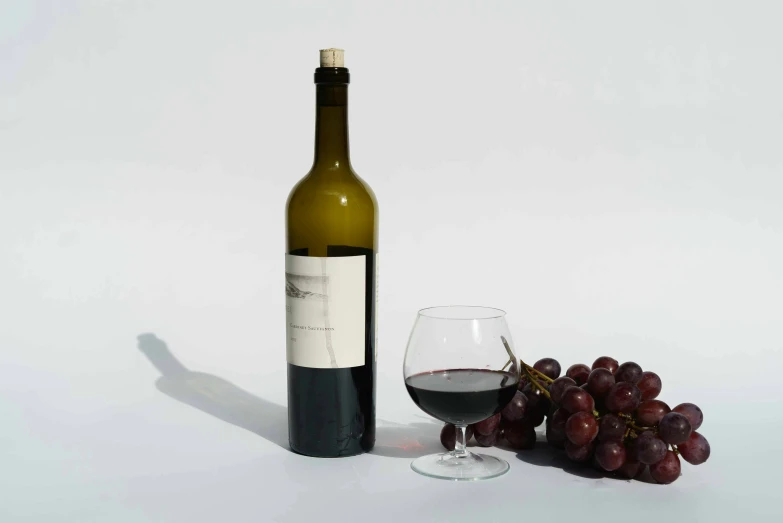 a bottle of wine sitting next to a glass of wine, by Carey Morris, pexels contest winner, photorealism, on grey background, modeled, set against a white background, ( ultra realistic