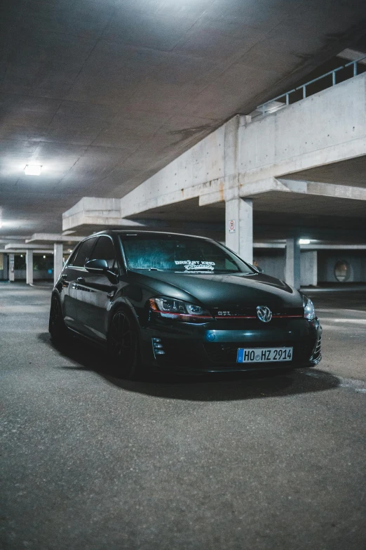 a black car parked in a parking garage, by Adam Marczyński, pexels contest winner, wrx golf, casually dressed, horned, low quality photo