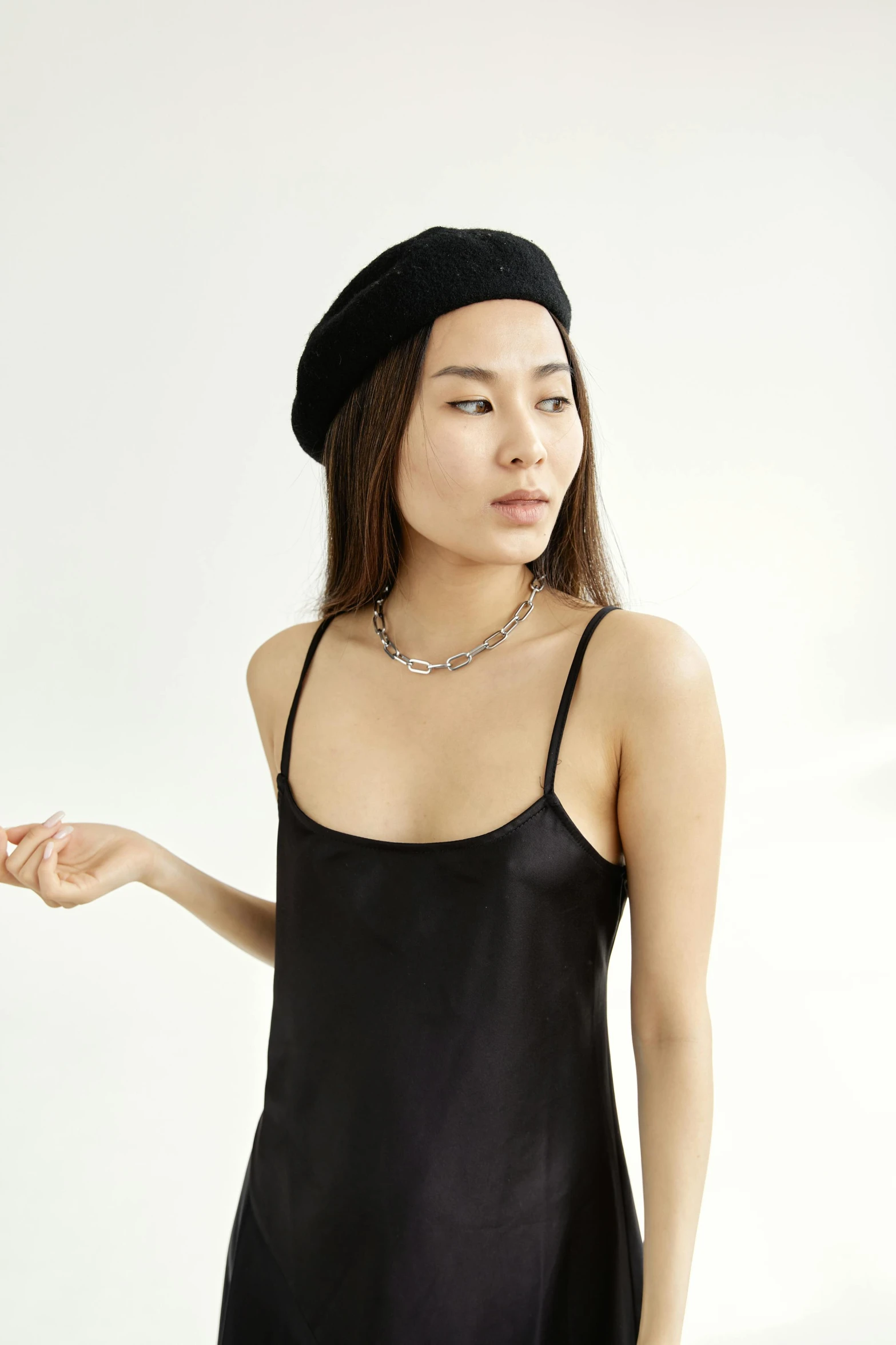 a woman wearing a black dress and a beret, wearing tank top, gold chain necklace, ross tan, main colour - black