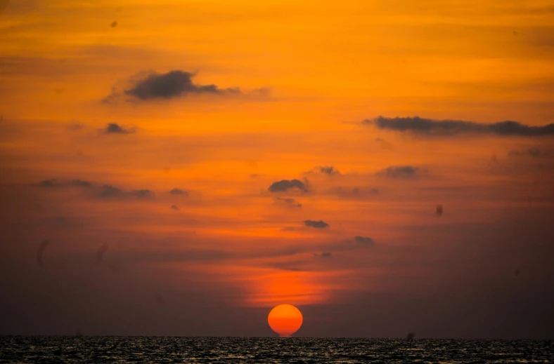 the sun is setting on the horizon of the ocean, by Carey Morris, pexels contest winner, sri lanka, bright yellow and red sun, aruba, journalism photo