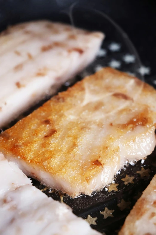 a close up of food cooking in a frying pan, inspired by Okada Hanko, sōsaku hanga, translucent skin, cod, grill, square
