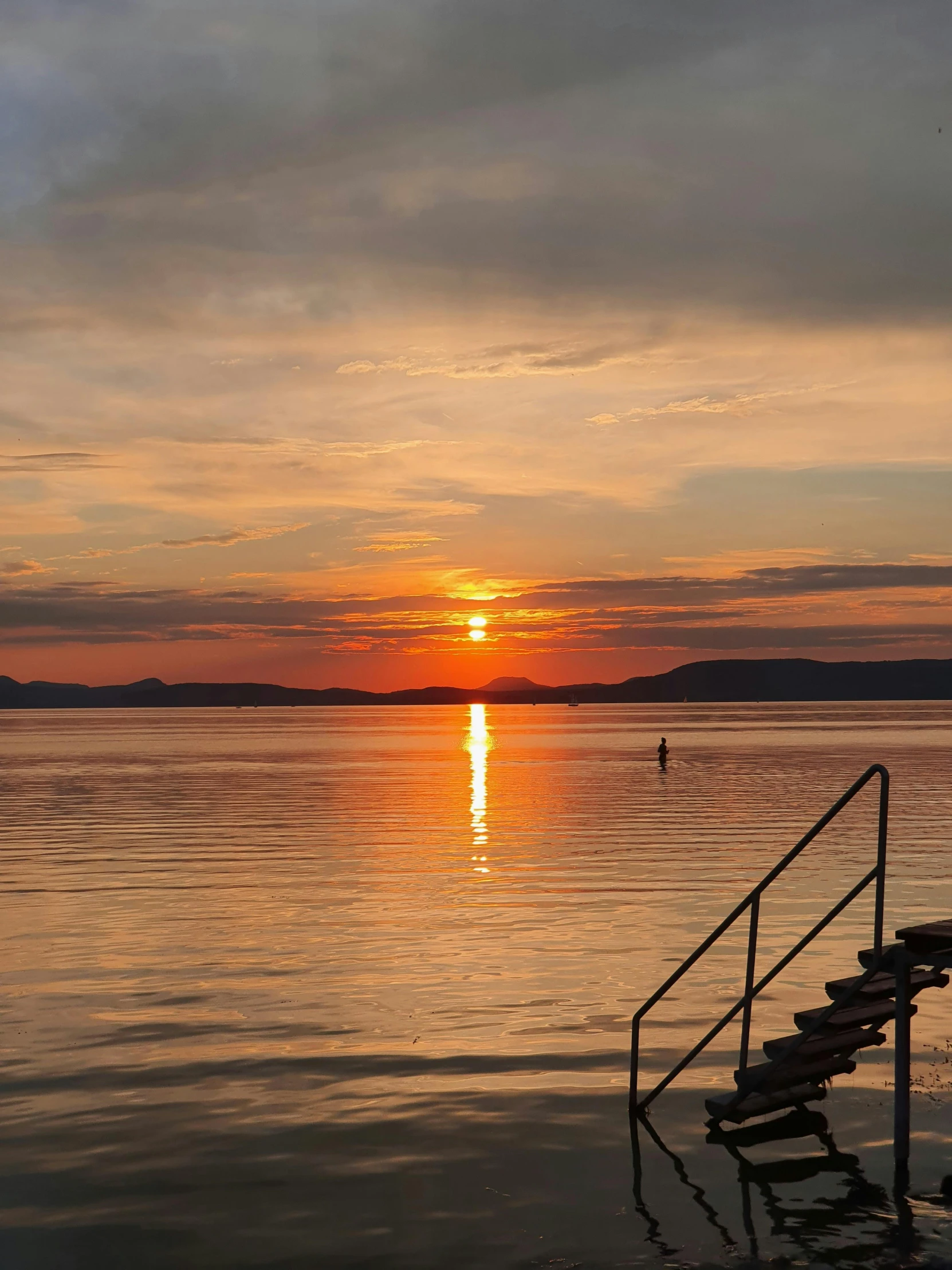 the sun is setting over a body of water, a picture, inspired by Jan Kupecký, happening, 8k hdr dusk light, swimming, at dusk!