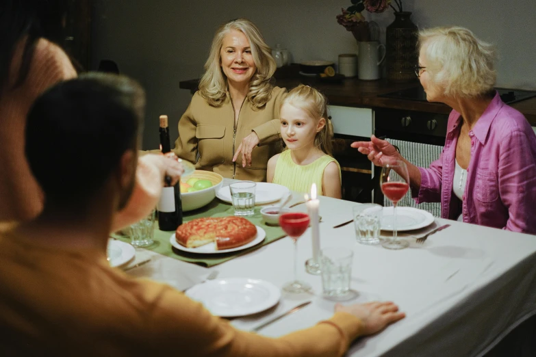 a group of people sitting around a dinner table, on a white table