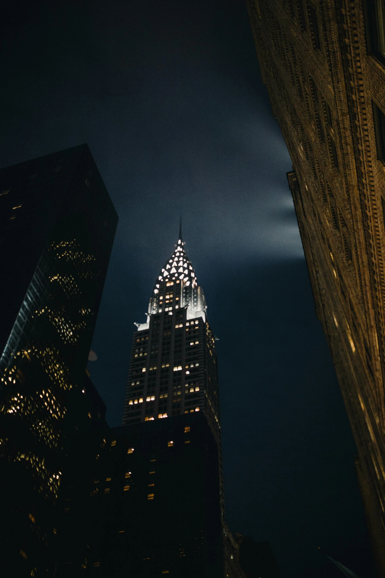 a very tall building lit up at night, unsplash contest winner, chrysler building, low quality photo, ilustration, ominous photo