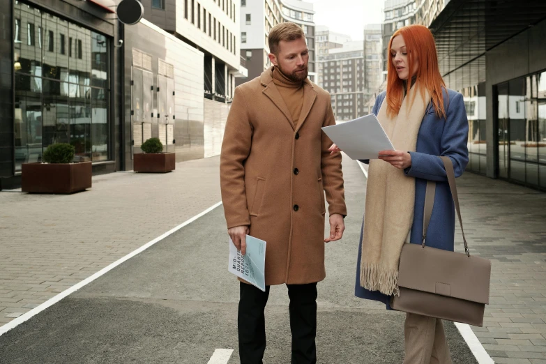 a couple of people that are standing in the street, pexels contest winner, holding a clipboard, hr ginger, light brown coat, thumbnail