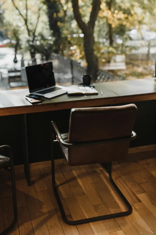 a laptop computer sitting on top of a wooden desk, chairs and tables, thumbnail, brown, design studio