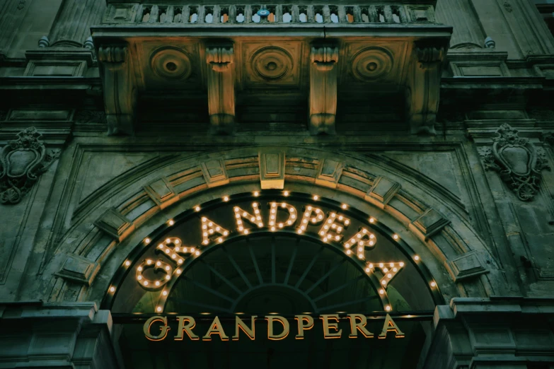 a clock that is on the side of a building, an album cover, by Antonio de la Gandara, unsplash contest winner, grand budapest hotel, dramatic theater lighting, grandfatherly, logotype