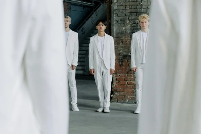 a group of young men standing next to each other, an album cover, by Emma Andijewska, pexels contest winner, antipodeans, dressed in white, luts, catwalk, soft white rubber