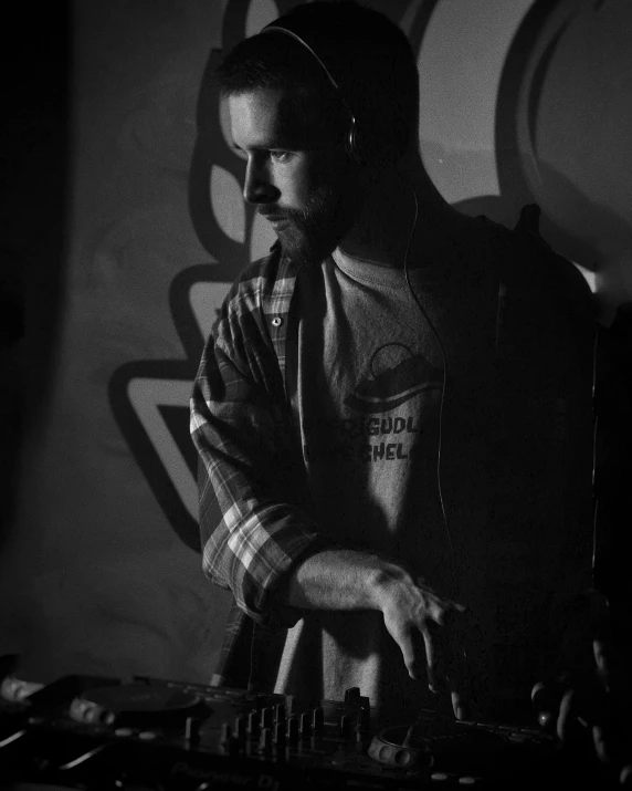 a man that is playing some kind of music, a portrait, unsplash, purism, mostly greyscale, dj mixer, lumberjack, looking seductive