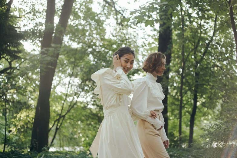 a couple of women standing next to each other in a forest, trending on pexels, renaissance, white dress shirt, walking at the park, off - white collection, single image