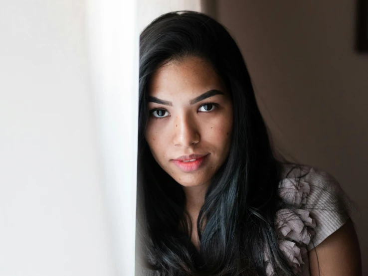 a woman with long black hair looking at the camera, a portrait, unsplash, hurufiyya, leaning against the window, mixed-race woman, roxie vizcarra, taken in the late 2010s