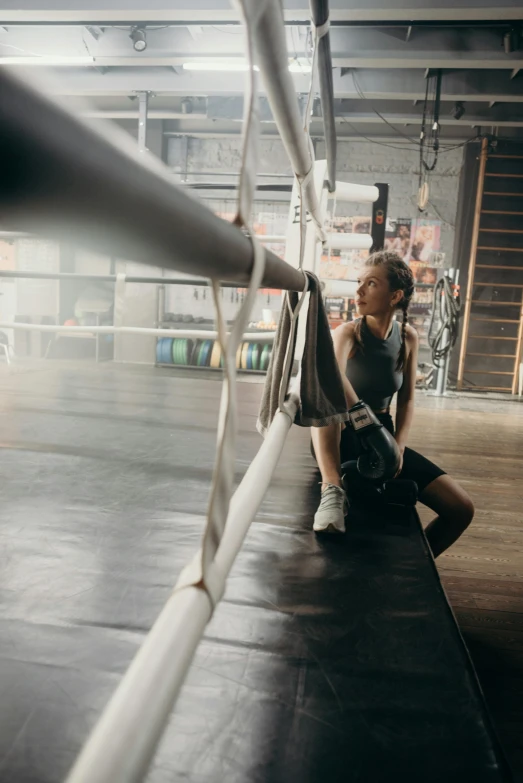 a woman sitting on a bench in a gym, pexels contest winner, happening, boxing ring, soft natural light, ropes, instagram story