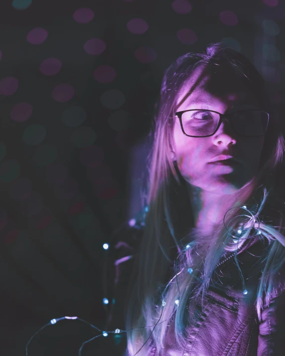 a woman with glasses standing in a dark room, inspired by Elsa Bleda, holography, purple lights, adafruit, photo of the girl, tactile buttons and lights