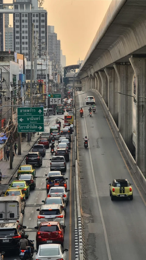 a highway filled with lots of traffic next to tall buildings, by Max Buri, a super-smart, buddhist, bridge, thumbnail