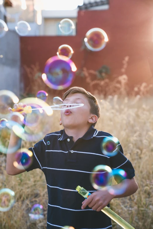 a young boy blowing bubbles in a field, pexels contest winner, fan favorite, light dispersion, next gen, profile image