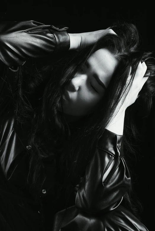 a black and white photo of a woman in a leather jacket, a black and white photo, unsplash, long dark hair, sleepy, alternate album cover, daoshi