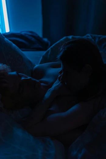 a couple of people laying on top of a bed, inspired by Nan Goldin, trending on reddit, blue backlight, lesbian embrace, movie still 8 k, cold scene