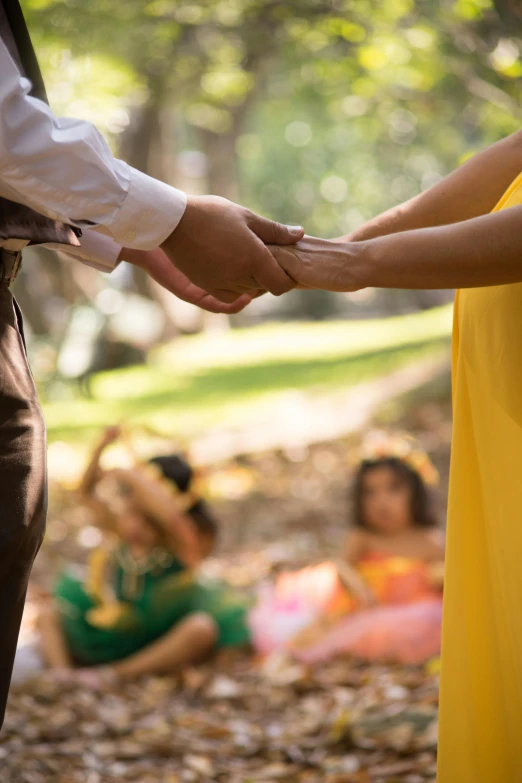 a man and a woman holding hands in a park, a cartoon, unsplash, renaissance, lady using yellow dress, sri lanka, ceremony, press shot