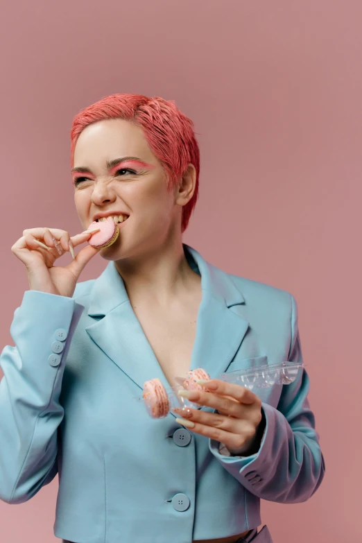 a woman with pink hair eating a donut, inspired by Elsa Bleda, trending on pexels, wearing a light blue suit, eating mars bar candy, non binary model, lily allen