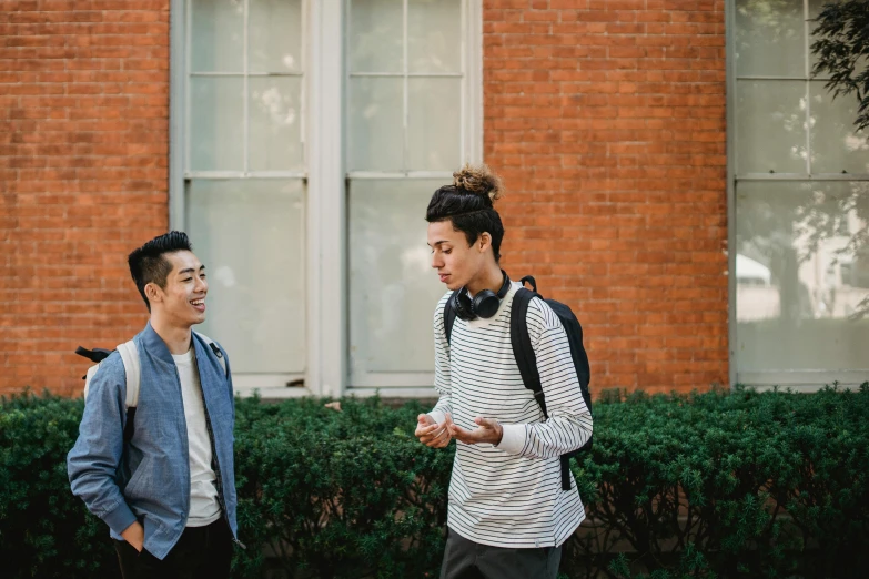 a couple of people standing in front of a building, happening, greg rutkowski and ross tran, college students, talking, easygoing