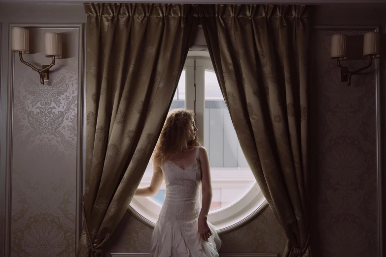 a woman in a wedding dress looking out a window, inspired by Elsa Bleda, pexels contest winner, renaissance, hotel room, curtains, a blond, medium format. soft light