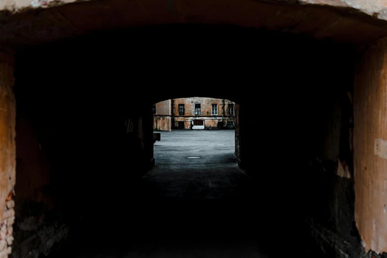 a red fire hydrant sitting in the middle of a tunnel, unsplash contest winner, minimalism, inside a castle courtyard, buildings covered in black tar, view from behind, brick building